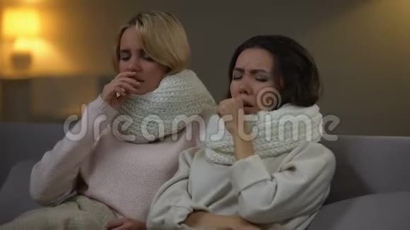 戴围巾的年轻女性躺在床上咳嗽流感病毒检疫视频的预览图