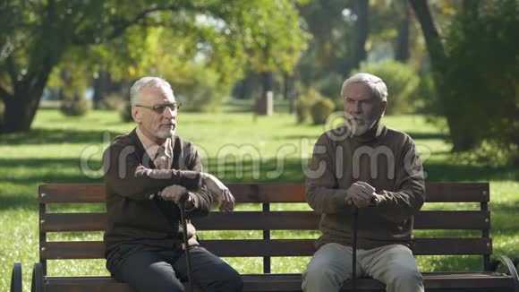 两个老人从长凳上站起来走着不同的路吵架了视频的预览图