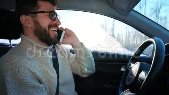 冬天一个人在城市之间的公路上开车他在说智能手机笑着他吓坏了视频的预览图