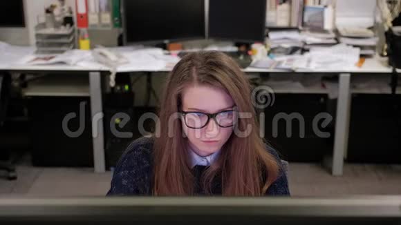 一个年轻的女人正热情地在电脑上工作视频的预览图