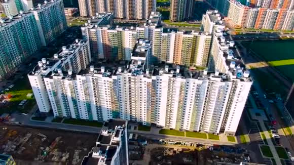 在夏季阳光明媚的一天建筑工地上有新的住宅高层建筑靠近绿地动作鸟瞰图视频的预览图
