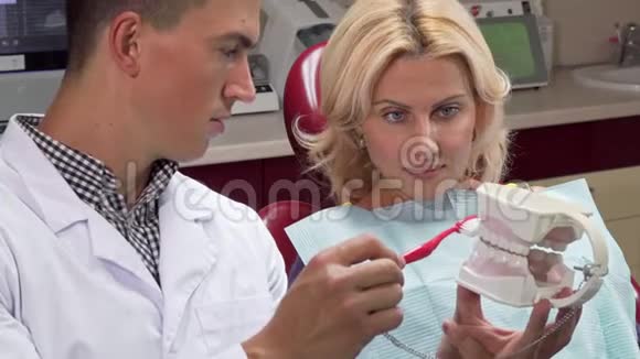 男牙科医生向病人展示如何在颌模上刷牙视频的预览图