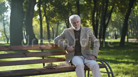 自信的老人下棋在公园放松晚年快乐生活视频的预览图
