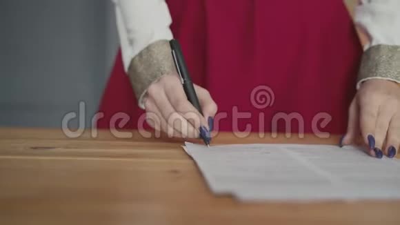 一个女人的手签文件的特写镜头视频的预览图
