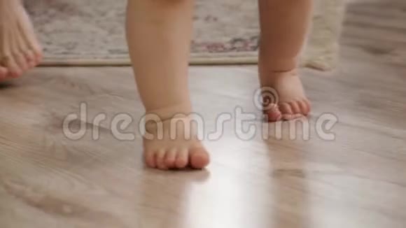 在让婴儿的第一步动作缓慢的过程中近距离观察婴儿的脚视频的预览图