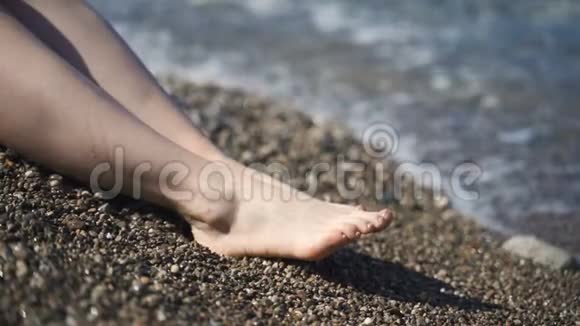 女性的双腿在浅海中飞溅海浪拍打着海岸视频的预览图
