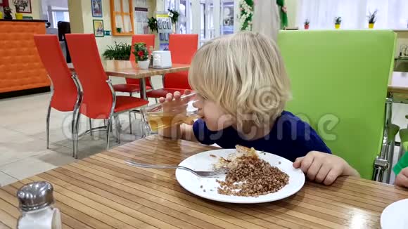 小男孩在咖啡馆里喝了一盘荞麦粥视频的预览图