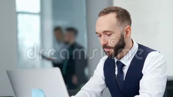 时尚胡子商人戴领带在现代办公室用笔记本电脑工作的肖像视频的预览图