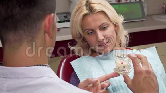 有魅力的成熟女人在他办公室和牙医谈话视频的预览图