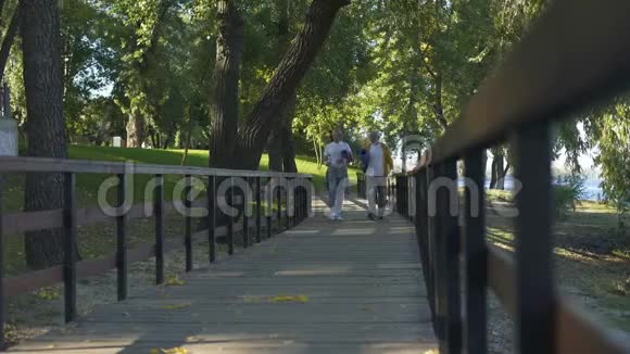 积极的退休人员在公园里散步带着瑜伽垫和水瓶锻炼身体视频的预览图