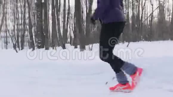 青年男女在冬林中奔跑一大早侧视图视频的预览图