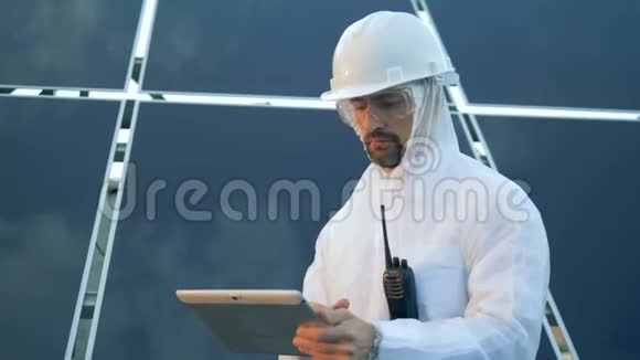 男性太阳能专家站在太阳能阵列前在发射机上讲话视频的预览图