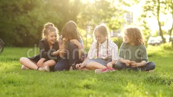 回学校学生放学快乐友好的同学坐在公园的草地上聊天视频的预览图