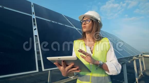 能源工程师正在操作她的电脑微笑地站在一个太阳能组件旁边视频的预览图