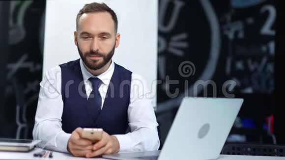 吸引人的时尚男性商人戴着领带使用智能手机和笔记本电脑的画像视频的预览图