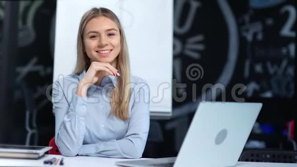 友好微笑的年轻女商人看着相机在现代办公室享受美好时光的肖像视频的预览图
