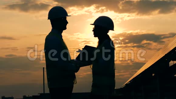日落时分两位工程师正在屋顶上谈话视频的预览图