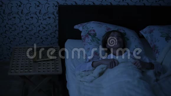 一个女孩在晚上醒来时的平均镜头是下床低调美国之夜的影响寒冷的夜晚视频的预览图