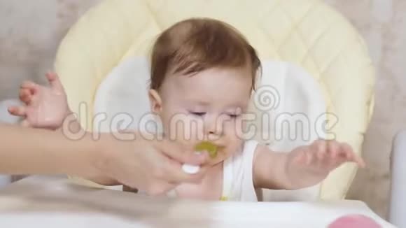 妈妈用土豆泥用勺子喂宝宝宝宝在孩子们桌子上吃早餐视频的预览图