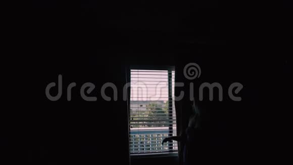 快乐的少女在酒店的公寓床上放松女孩锁在窗户上暑假心情视频的预览图