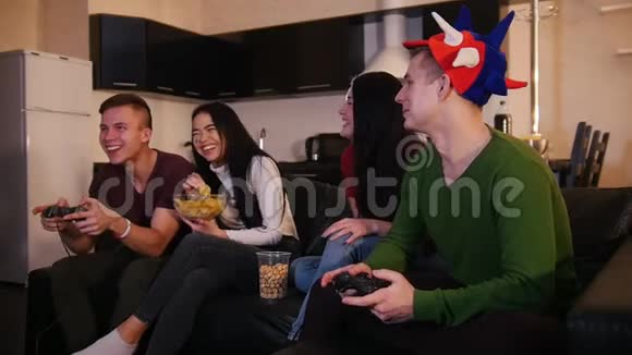 两个年轻人在玩游戏而他们的女朋友在谈论游戏视频的预览图