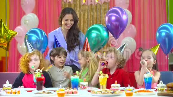 孩子们戴着五颜六色的帽子和母亲和恶魔一起庆祝生日视频的预览图
