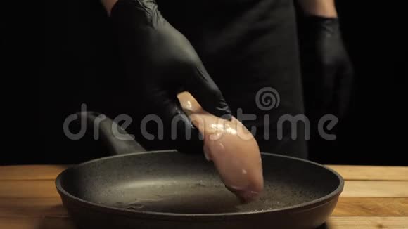 厨师把戴手套的鸡片放在热煎锅上视频的预览图