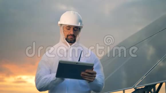 男性能量学工作者停止操作平板电脑并观看摄像机视频的预览图