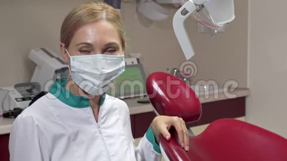 开朗成熟的女牙医摘下她的医疗面具微笑着视频的预览图