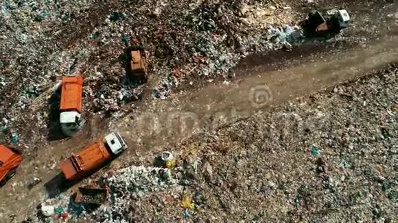大橙色垃圾车在废墟中移动垃圾填埋现场的工作设备视频的预览图