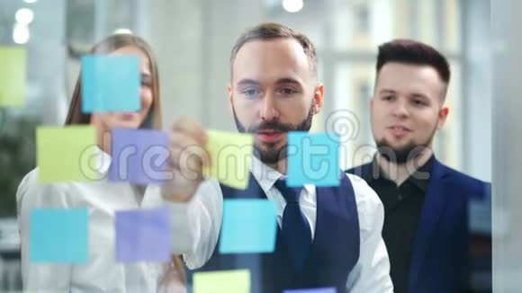 有魅力的商人在办公室规划和头脑风暴中使用多种颜色的粘性笔记视频的预览图