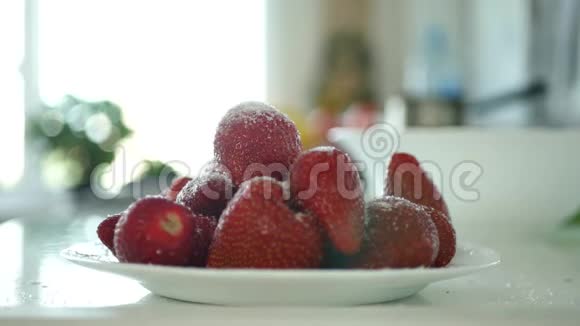 男人手把白糖放在装满草莓水果的盘子里视频的预览图