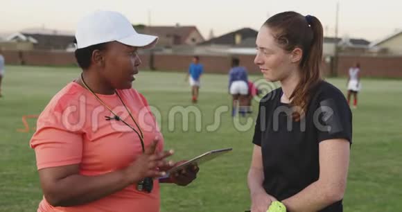 年轻的成年女性橄榄球运动员和训练教练视频的预览图