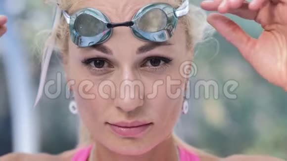 年轻漂亮的女孩看着相机额头上戴着游泳眼镜视频的预览图