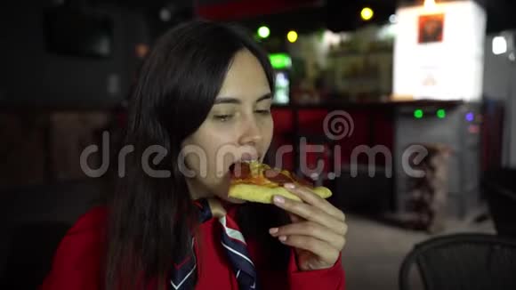 漂亮的女孩吃披萨在咖啡馆里微笑视频的预览图