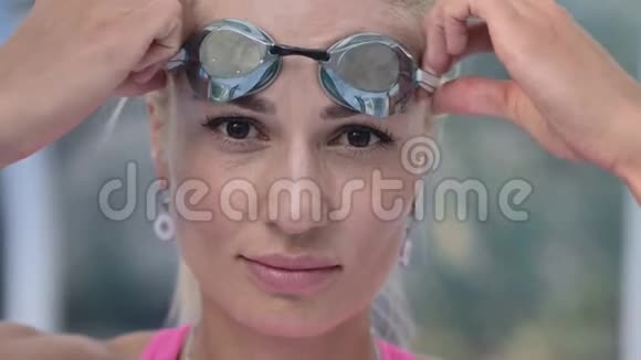 年轻漂亮的女孩看着相机额头上戴着游泳眼镜视频的预览图