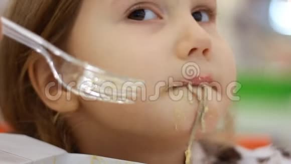 孩子吃有奶酪的意大利面小女孩在盒子里吃快餐意大利面视频的预览图