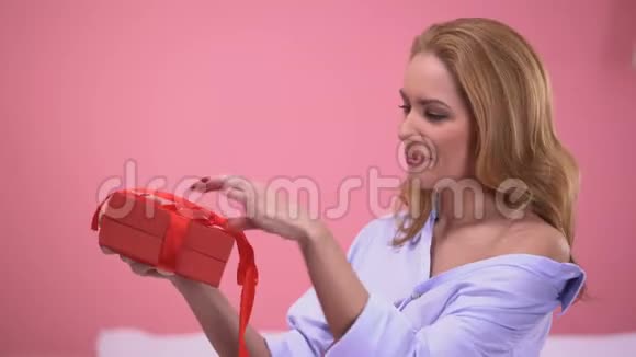 有魅力的女人非常高兴在红色礼品盒情人节视频的预览图