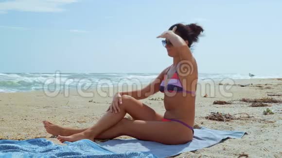 一位戴着苏尔扎希特尼眼镜的美女躺在海边眺望远方视频的预览图