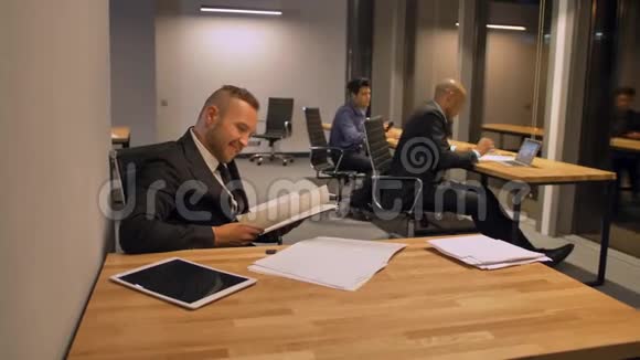 自信的老板和同事在夜班处理文件视频的预览图