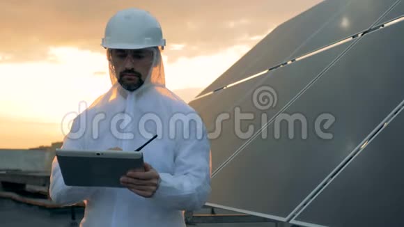 屋顶上的日落景观一位男性专家在太阳能电池旁的发射器上讲话视频的预览图