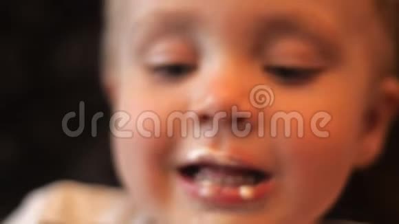 一个小男孩的肖像他舔着华夫饼杯中的白色甜香草冰淇淋嘴里抹着冰视频的预览图