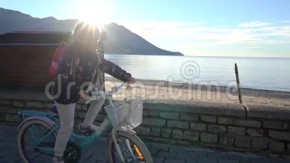 早晨六岁的女孩骑自行车沿着海滨上学视频的预览图