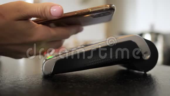女人用手机的手用终端付款非现金交易视频的预览图