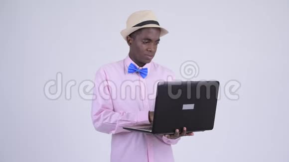 年轻快乐的非洲游客边用笔记本电脑边思考视频的预览图