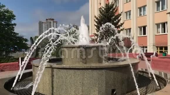 在繁忙的城市街道上工作喷泉慢动作靠近高层建筑视频的预览图