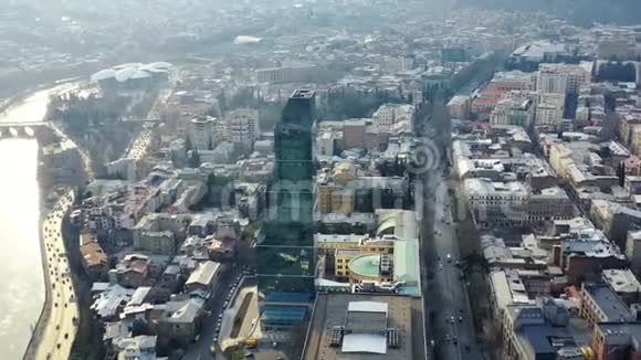 空中拍摄到一座巨大的玻璃摩天大楼背景是繁忙的道路4k视频的预览图