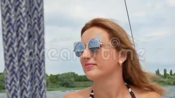 美丽的女孩浅棕色的头发躺在游艇和日光浴上视频的预览图