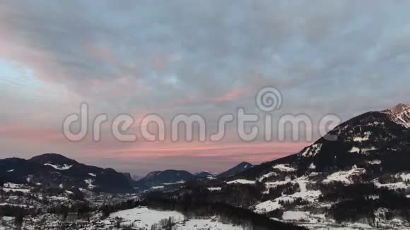 空中拍摄的雪山村庄和五彩缤纷的天空4k视频的预览图