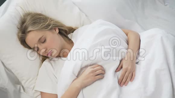 反复无常的女孩在头上拉毯子想在早上多睡一会儿视频的预览图